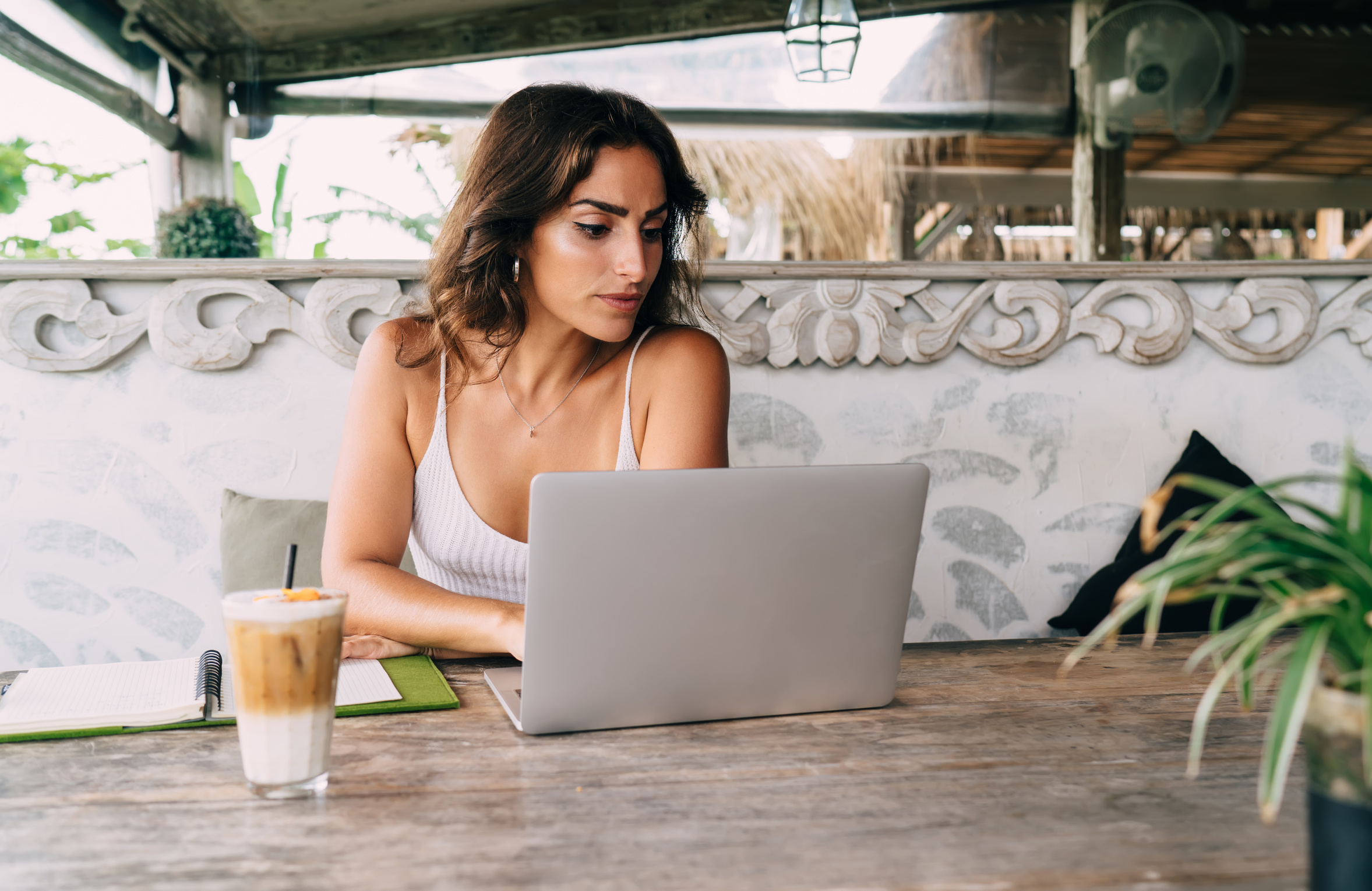 Self Employed Ethnic Female Working on Laptop in Summer Cafe